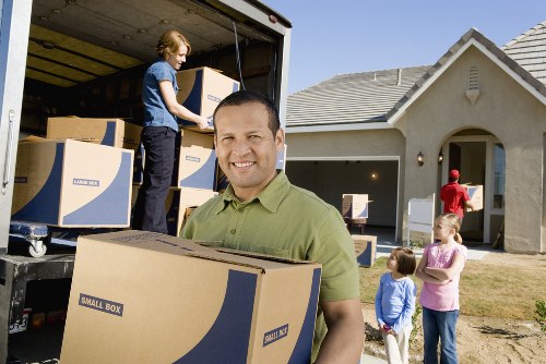 Movers carrying furniture through a house staircase